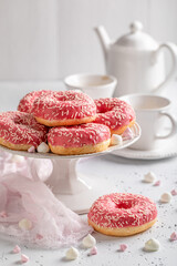 Sweet and homemade pink donuts and coffee ready to eat.