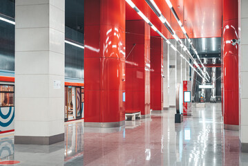 Moscow, Russia - 8 June 2023: Moscow metro station in red colors and a train standing at the platform.