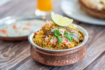 Spicy Indian biryani pulao in golden bowl with India basmati rice dish with chicken meat curry