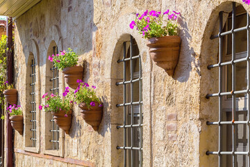 Fototapeta na wymiar House wall with rythmic flowerpots. Old town street, public space, Antalya, Turkey