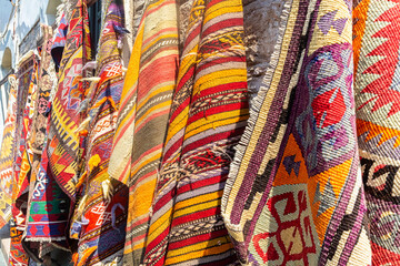 Colorful carpets and rugs at the street gift shop. Typical handmade souvenir for tourists. Antalya old city, Turkey (Turkiye)