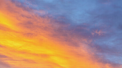 Dramatic cumulus clouds on sunny day at sunset painted with sun. Atmosphere multicolor background or wallpaper