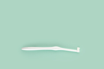 special toothbrush for cats and small dogs on a green background, copy space