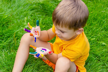 Children's hands in the colors of summer, a smile on the boy's palm.