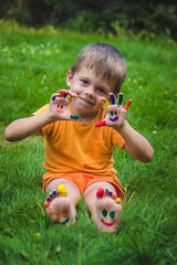 Children's hands in the colors of summer, a smile on the boy's palm.