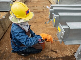 The worker is using a rasps to clean the surface of the hole so that the paint job can be preserved.