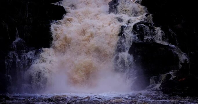 Waterfall in the Republic of Karelia, Russia. The picturesque nature of a beautiful waterfall and an emerald pool of a freshwater lake in the wild forests of the jungles of Karelia.