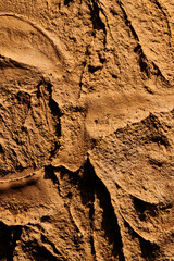 Decorative brown ocher putty background. Wall texture with filler paste applied with spatula, chaotic dashes and strokes over plaster. Creative design, stone pattern, cement.