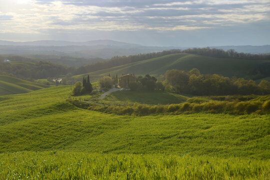 A landscape photo of a house on a hill in Toscana during a sunset 