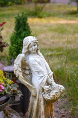 Obraz premium Kindlicher Engel mit Korb an Grabstätte