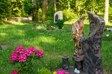 Geschmücktes Grab mit Engelsfigur, Friedhof