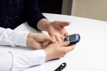 Doctor measure the patient's glucose level. Close-up Of Doctors And Using Glucometer On Patient's Finger. Concept Diabetes control glucose in blood