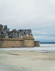 Partie basse de la muraille du Mont-Saint-Michel avec d'anciennes maisons médiévale. Devant, du...