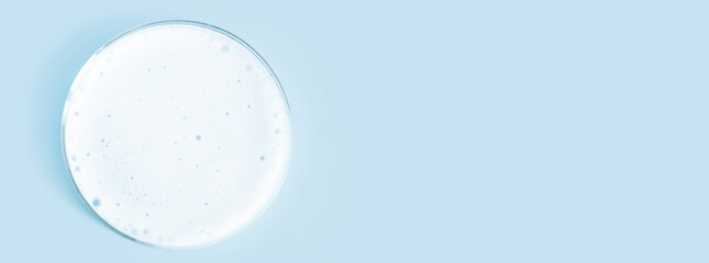 Washing agent foam in a Petri dish. On a blue background.