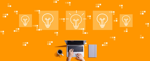 Idea light bulb theme with person working with a laptop