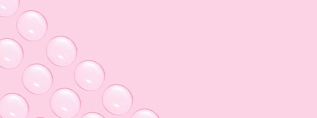 Drops of clear gel or water in rows. On a pink background.