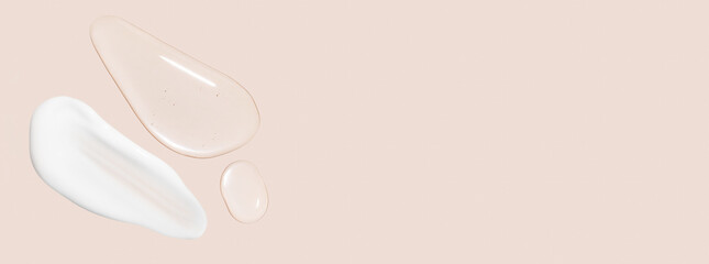 Drops of transparent gel and a dab of white cosmetic cream. On a beige background.