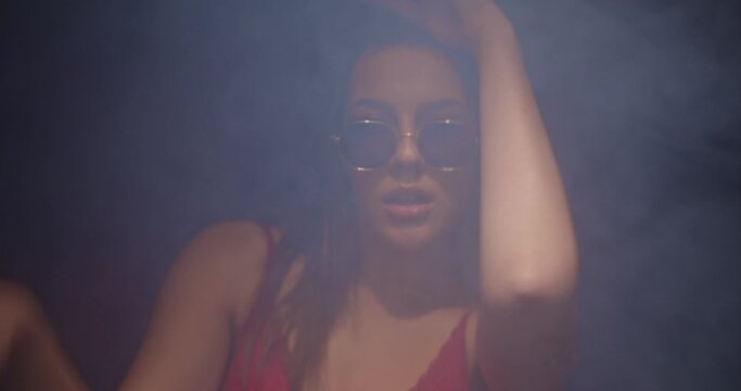 Cool girl with sunglasses smoking and dancing seductively