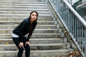 Young female athlete resting after running outdoors