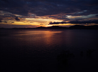 Dramatic aerial landscape with sunset on the sea shore. Beautiful cloudy sky.