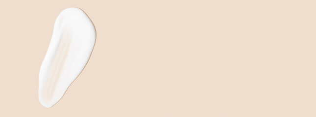 The flowing cream on a beige background. Smudged flowing smear of cosmetic cream.
