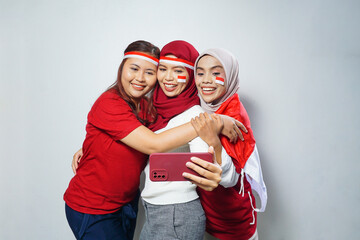 Fototapeta premium happiness of a group of young people using the red and white attributes to commemorate independence day