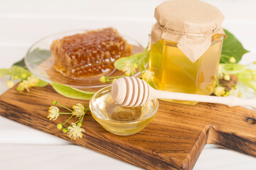 Linden honey with leaves and flowers on table