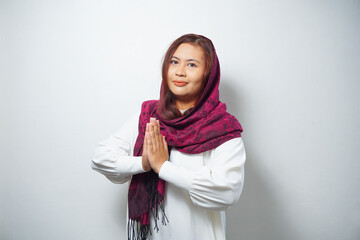 Portrait of a young beautiful Asian Muslim woman wearing a hijab gesturing Eid Mubarak greeting