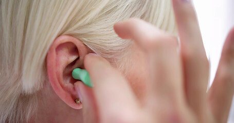 Woman Putting Earplug Into Her Ear
