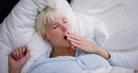 Young Woman Yawning In Bed