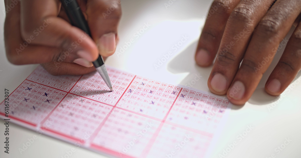 Wall mural person's hand marking number on lottery ticket