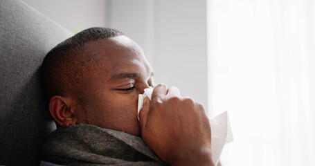 Young Man Infected With Cold Blowing His Nose