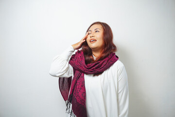Shocked Asian Muslim woman wearing headscarf with her mouth wide open, isolated by white background