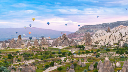 Fototapeta premium Cappadocia. Hot air balloons flying over Cappadocia in a dramatic sky. Travel to Turkey. Selective focus included.