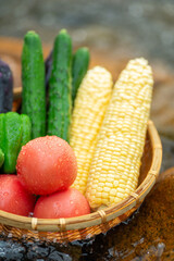 清流とザルに入れた夏野菜