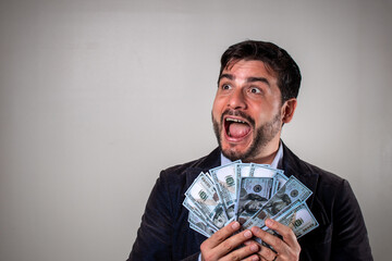 Hombre feliz sosteniendo muchos billetes de 100 dolares