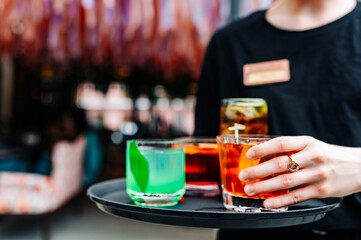 glasses alcohol cocktail set on a waiter tray outdoor cafe