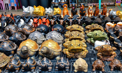 Collection of colourful Thai animal statues for sale, to be used as home and garden ornaments: frogs, turtles, buffalos, pigs and dogs
