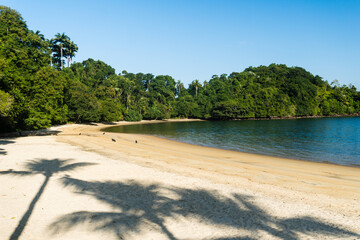 Beautiful beach in Angra do Reis, green coast of Rio de Janeiro. Tanguá Beach. Hills and mountains in the background on a sunny day. Crystal clear water. Dawn