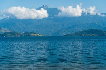 Beautiful beach in Angra do Reis, green coast of Rio de Janeiro. Tanguá Beach. Hills and mountains in the background on a sunny day. Crystal clear water. Dawn