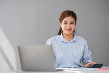 Business woman using calculator for do math finance on wooden desk in office and business working background, tax, accounting, statistics and analytic research concept.