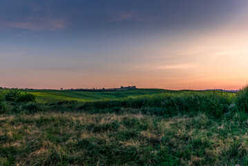 The green tuscan hills in the Orcia Valley in spring in the evening
