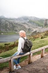Fototapeta na wymiar woman sitting enjoying the green landscape of the Lakes of Covadonga in the Picos de Europa. In Asturias, Spain.