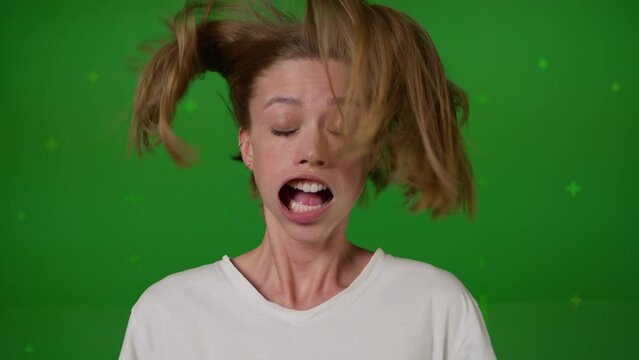 Caucasian girl in front of TV screen getting blown away. Cinema concept with chroma key.