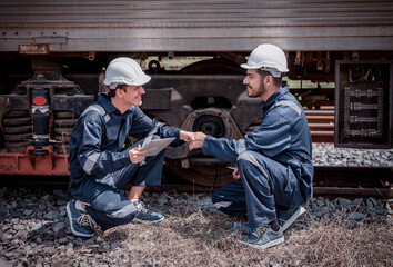 Fototapeta na wymiar Engineer railway posing hand shake best cooperation inspection, checking train testing and checking railway work on railroad station Engineer wearing safety uniform and safety helmet in work.