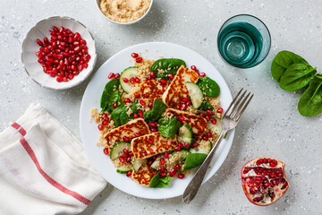 healthy halloumi cheese and couscous salad with cucumber spinach pomegranate hummus