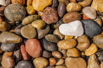 Colorful boulder pebble beach stones background seamless texture for design. Natural rounded gravel at sea shore Nature background texture pattern