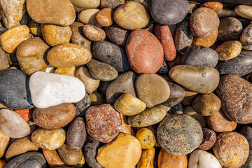 Colorful boulder pebble beach stones background seamless texture for design. Natural rounded gravel at sea shore Nature background texture pattern