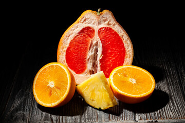 sliced tropical fruits mix on wood background