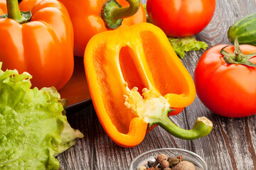 sliced orange bell pepper on wood background